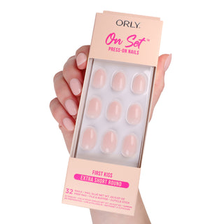 Orly press-on nails packaging held by a hand with pink nails on a white background