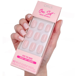 Orly press-on nails packaging held by a hand with matching nails on a white background