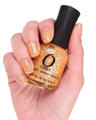 hand holding orange glitter topper nail polish bottle
